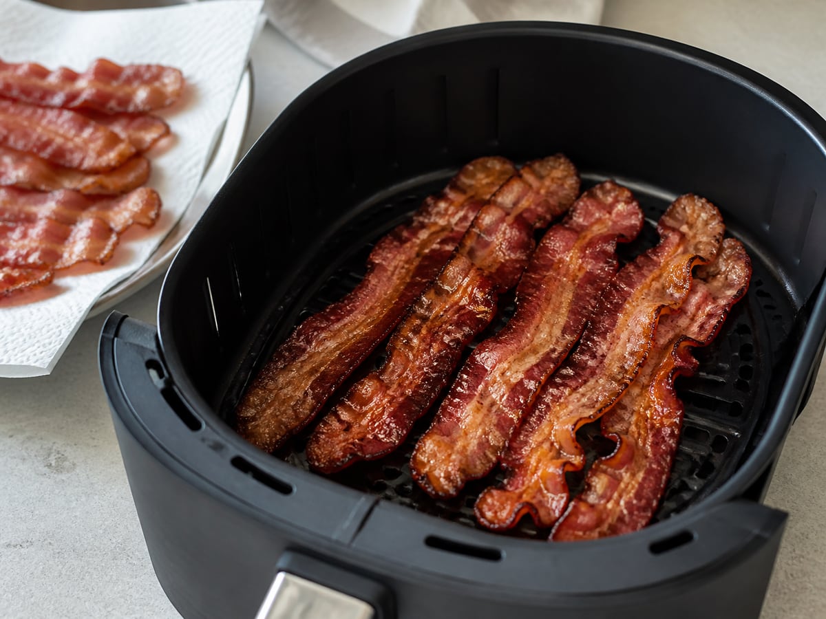 Air fryer basket with cooked bacon